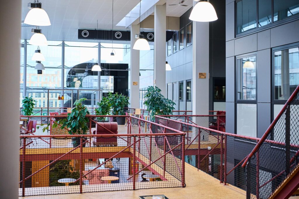 Moderne en lichte kantoorruimte aan het John M. Keynesplein met grote ramen, planten en zitgedeelte.